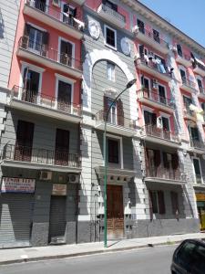 um edifício com um relógio na lateral em Chiarini22 Apartments em Nápoles