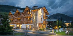 a large building with a mountain in the background at Hotel Silvestri in Livigno