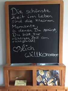 a chalkboard with writing on it on top of a shelf at Huus 38c in Westerdeichstrich