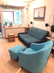 a living room with a couch and two blue chairs at Huus 38c in Westerdeichstrich