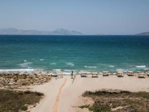 a beach with umbrellas and chairs and the ocean at OKU Kos in Marmari