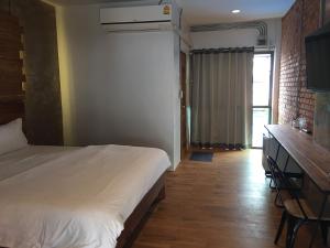 ein Schlafzimmer mit Bett, Schreibtisch und Fenster in der Unterkunft De Nan Hotel in Nan
