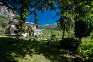 a house in the middle of a yard with trees at Agriturismo Maso Lizzone in Dro