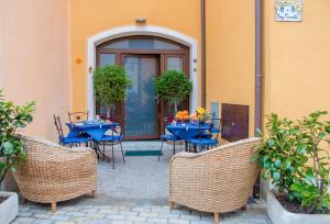 un patio con tavoli e sedie blu di fronte a un edificio di B&B Borgo Marinella a Sapri