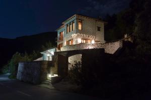 a large stone building with lights on it at night at Dionysos Villa in Keramídhion