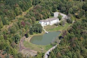 een luchtzicht op een groot huis met een meer bij River Spring Lodge in Darien