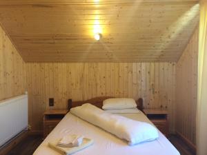 a room with a bed in a wooden cabin at Cabana 7 Brazi in Poiana Mărului