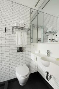 a white bathroom with a toilet and a sink at Pod Times Square in New York