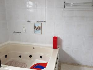 a bathroom with a tub and a bathtub at Pluma Hotel Cidade in Americana