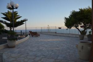 un patio con panchine, recinzione e oceano di LOFT NICOLIZIA - Area Esterna Esclusiva con Vista Mare a Licata
