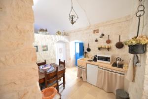 a kitchen and dining room with a table and a microwave at Masseria Oreglia in Ceglie Messapica