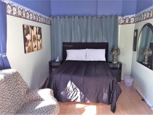 um quarto com uma cama com paredes roxas e um sofá em Maison du Moulin em L'Isle-aux-Coudres