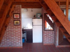 a kitchen with a refrigerator and a brick wall at Tierra Mandarina Cabañas in Gualeguaychú