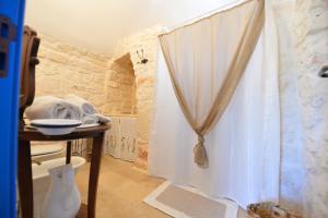 a bathroom with a shower curtain and a table at Masseria Oreglia in Ceglie Messapica +145 photos