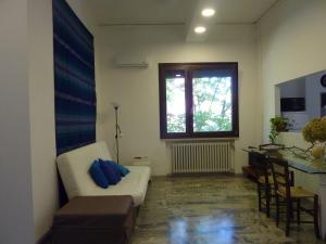 un soggiorno con divano bianco e finestra di B&B Il Melograno a Mantova