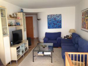 sala de estar con sofás azules y TV en Blue Ocean, en Platja d'Aro