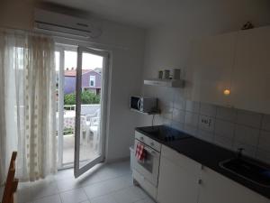 uma cozinha branca com vista para um pátio em Apartment Saric em Sukošan