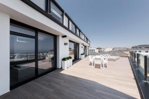 a balcony with tables and chairs on a building at Apartahotel A Cetárea in Burela de Cabo