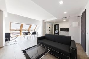 a living room with a black couch and a table at Apartahotel A Cetárea in Burela de Cabo