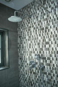 a shower in a bathroom with a tiled wall at Melita corner apartment in Valletta