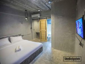 a bedroom with a bed and a flat screen tv at UdonBackpackers Beds and Cafe in Udon Thani