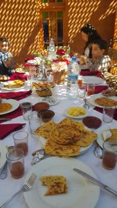 una mesa larga con platos de comida. en Chez Mamouchthka en Ourika