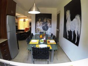 a kitchen with a dining table with a horse painting on the wall at Villa Galleria in Perivolia