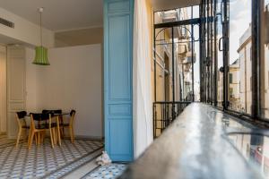 een balkon met een blauwe deur en een tafel en stoelen bij Eva Recommends Casa Gerona in Sevilla