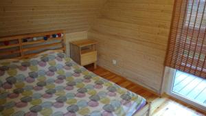 een kleine slaapkamer met een bed en een raam bij Domek nad morzem Mechowo in Mechowo