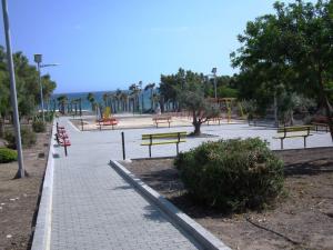 a park with benches and trees and a sidewalk at Villa Galleria in Perivolia