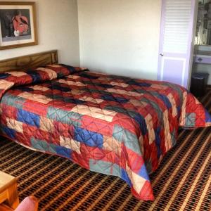- une chambre avec un lit doté d'une couette colorée dans l'établissement Relax Inn - Shelby, à Shelby