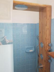 a blue tiled bathroom with a shower with a glass door at Villa Akwaba in Pyla-sur-Mer +37 photos