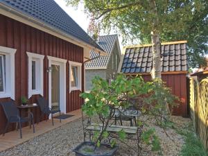 einen Garten mit Stühlen und einem Zaun und einem Haus in der Unterkunft Ferienwohnungen im Schwedenstil in Papenburg