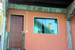 a door and a window on a house at Suite JC in Visconde De Maua