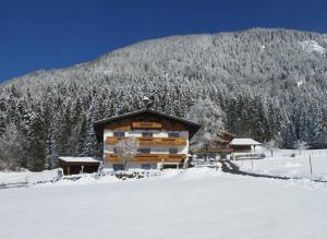ein Blockhaus im Schnee mit einem Berg in der Unterkunft Stallerhof in Sankt Jakob in Haus