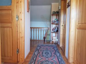 a hallway with a rug on a wooden floor at Casuta dintre dealuri in Vlădeşti