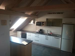 een keuken met witte kasten en een zwart aanrecht bij Apartmán Jakubka in Teplice nad Bečvou