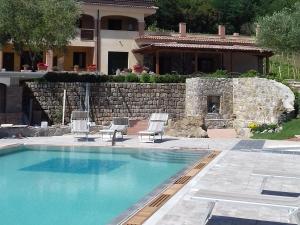- une piscine avec 2 chaises et une maison dans l'établissement Tenuta del Bifan, à Policastro Bussentino