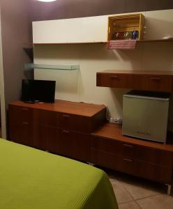 a bedroom with a bed and a desk with a laptop at Al 32 y 3 in Alghero