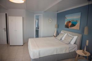 コキノス・ピルゴスにあるGolden Sunのベッドルーム1室(白いベッド1台、青い壁付)
