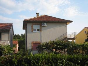 une maison blanche avec une fenêtre et un toit dans l'établissement Apartments Sandra, à Novigrad