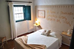 a bedroom with a white bed and a window at Casa Do Relogio in Óbidos