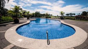 a large blue swimming pool in a parking lot at Ocean View Condo in Los Sueños in Herradura