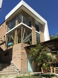 una casa con ventanas grandes en un lateral en "Bambú Sierra" Cozzy Ecológical Lofts, en Cuenca