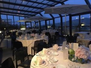 ポテンツァにあるグランデ アルベルゴ ポテンザの白いテーブルと椅子、パラソルが備わるレストラン