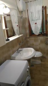 bagno con lavandino bianco e servizi igienici di Locazione Turistica Casa Vacanza Lola a Castiglion Fiorentino