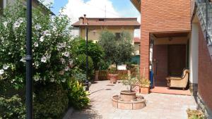 un patio con fiori e una sedia in una casa di Locazione Turistica Casa Vacanza Lola a Castiglion Fiorentino