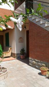 un edificio con un muro di mattoni e una sedia in un cortile di Locazione Turistica Casa Vacanza Lola a Castiglion Fiorentino