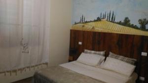 una camera con letto e testata in legno di Locazione Turistica Casa Vacanza Lola a Castiglion Fiorentino