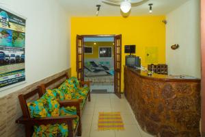 um quarto amarelo com duas cadeiras e um bar em Pousada Príncipe dos Mares em Paraty